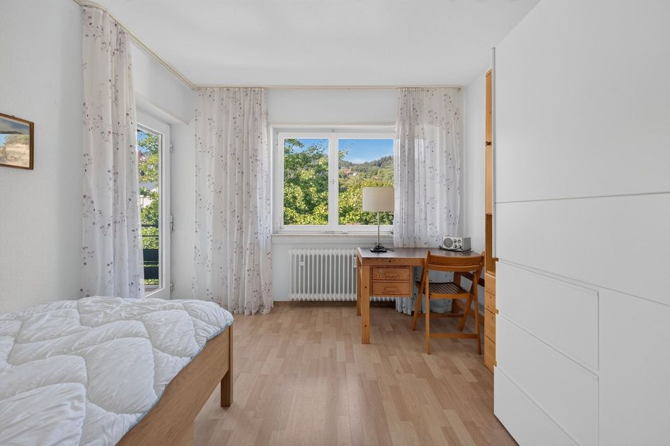 Schlafzimmer mit Fenster, Gardinen und Schreibtisch